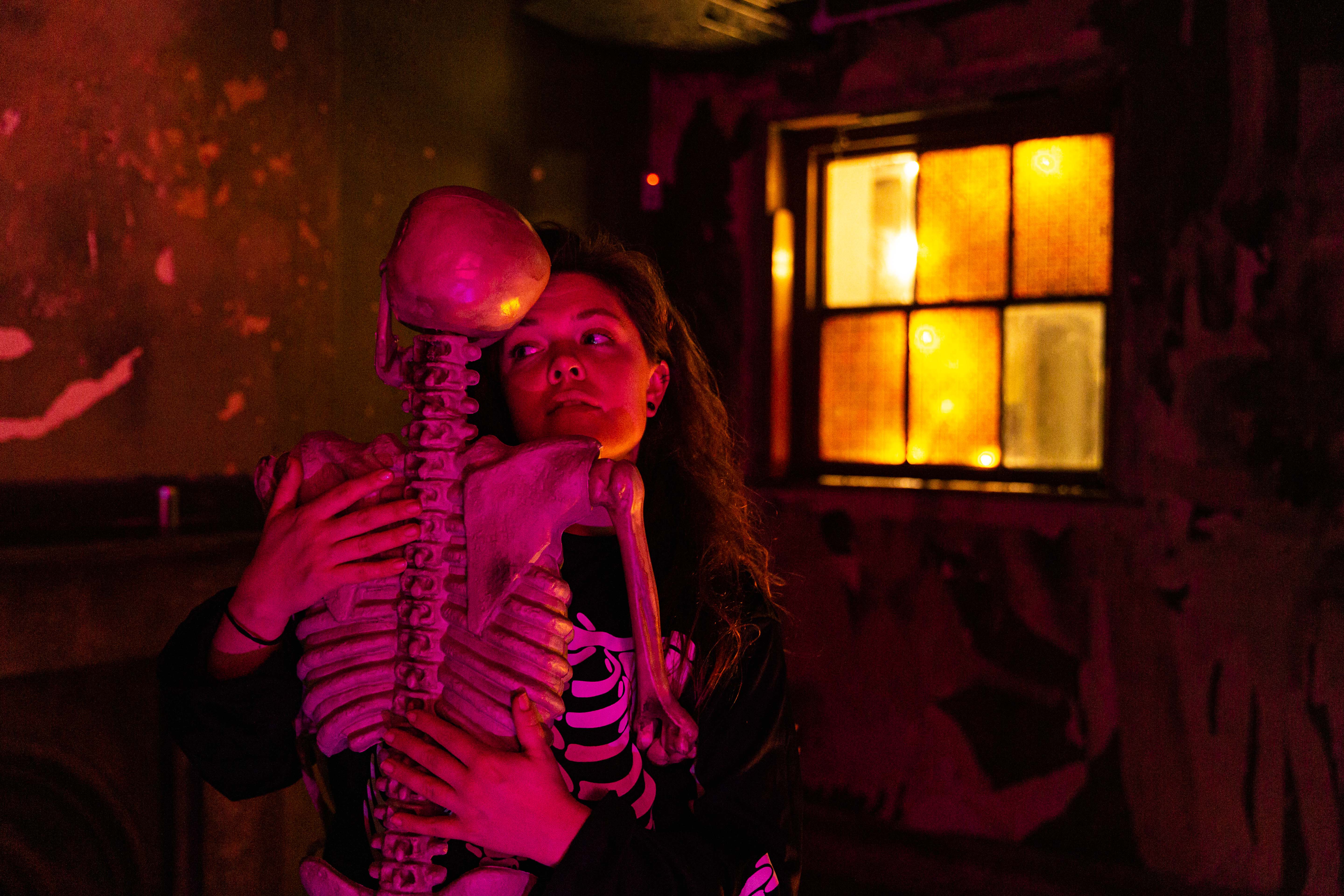A woman embraces a skeleton