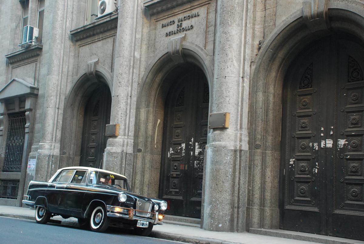 Façade of the Banco de Desarrollo with Oscar Serrano's original taxi.jpg